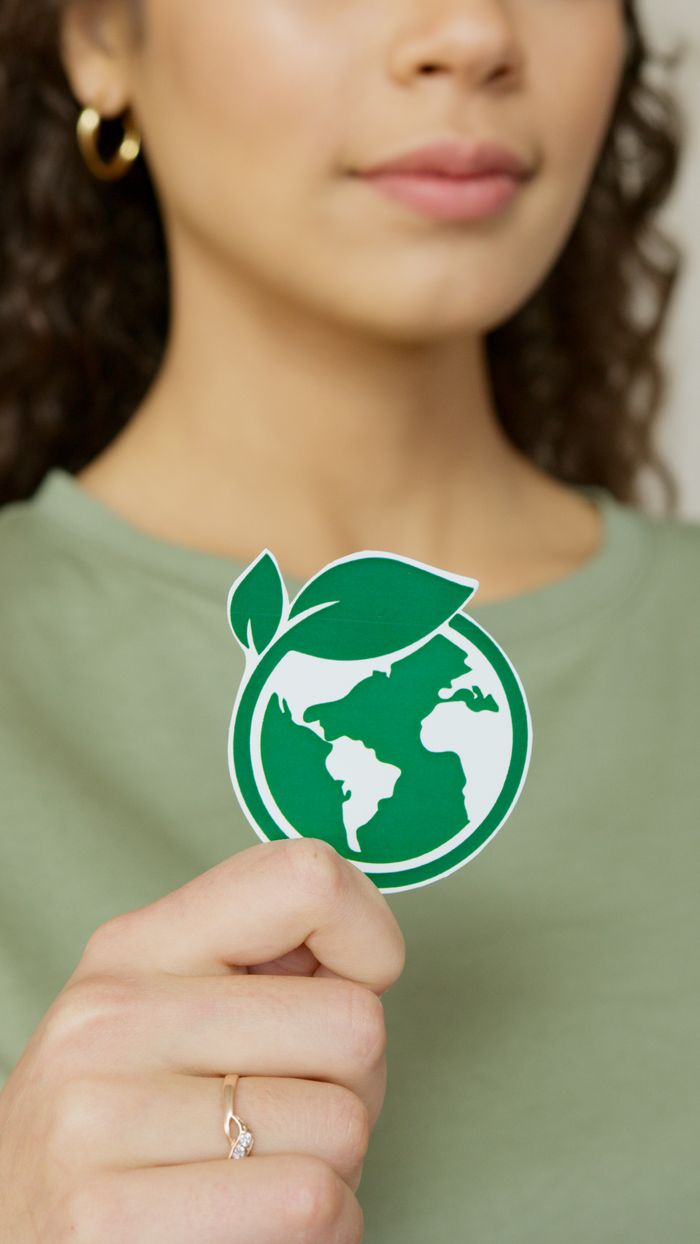 Home Close-up of a woman holding a green earth symbol, emphasizing environmental protection.